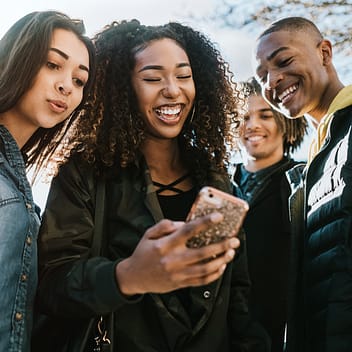 Group of young people looking at something on a phone